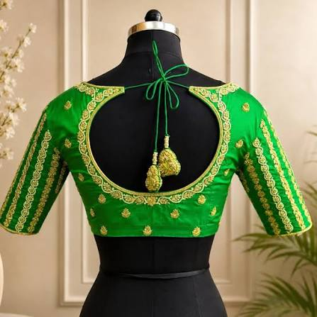 Back view of a parrot-green silk blouse with a large round cut-out, gold embroidered edging and a dori tie finished with two gold tassels.