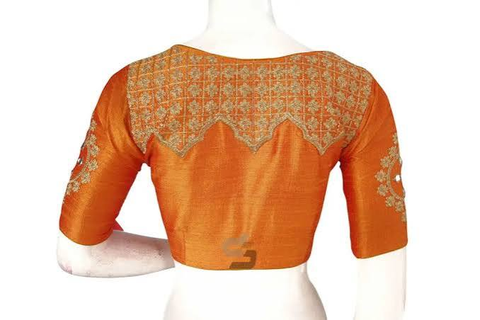 Back view of a rust raw-silk blouse with a scalloped gold embroidered yoke across the upper back and gold buti work on the elbow sleeves.